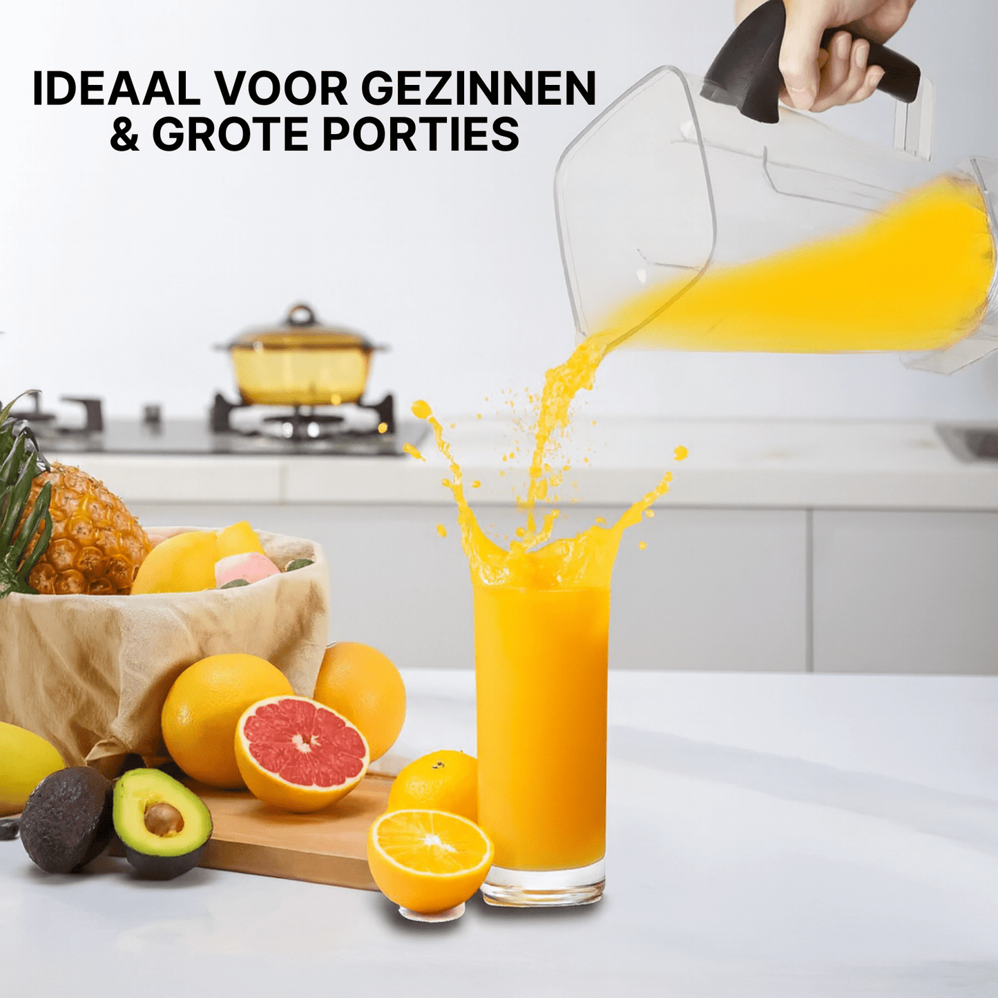 Transparante blenderkan giet vers sinaasappelsap in glas, met citrusfruit en ananas op aanrecht.