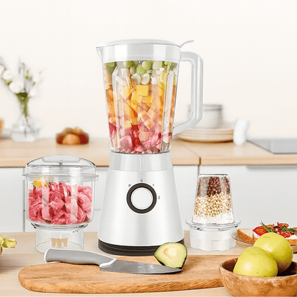 Witte NutriBlend blender met stukjes fruit, vlees en noten in drie opzetstukken op een keukenblad.